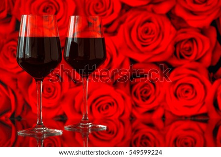 Two glasses of red wine against bokeh background with sparkles and roses. Very shallow depth of field. Selective focus, copy space