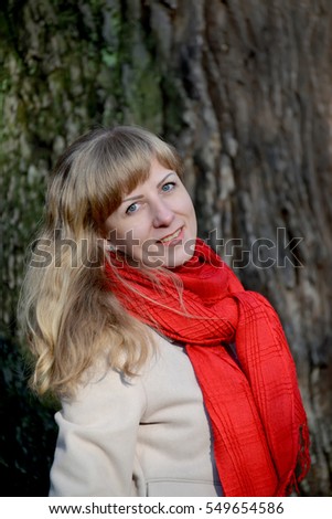 Portrait of the young fair-haired woman against the background of a tree