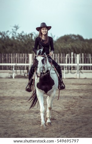 The Asian cowgirl riding a horse.