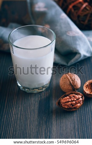Glass of milk a wooden table. Dark background.