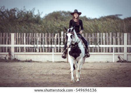 The Asian cowgirl riding a horse.