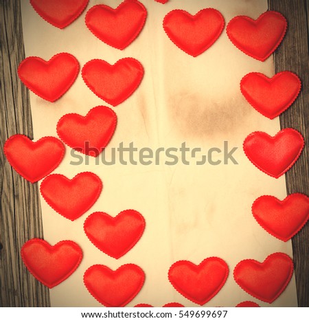 blank old paper with red hearts on old wooden surface background. copy space. instagram image filter retro style