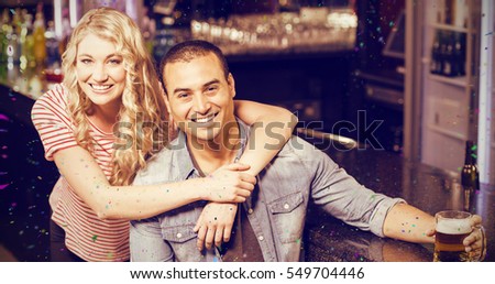 Smiling couple having a drink against flying colours