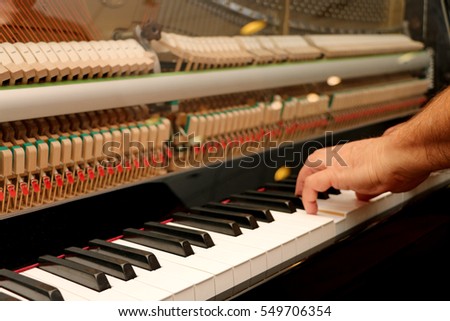 Someone plays piano, close up piano, white and black keyboard