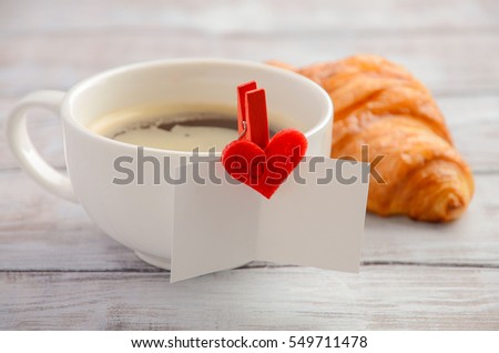 Cup of fresh morning coffee with croissant. Valentine's day concept.
