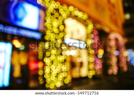 blurred photo of street background in snowy night with christmas lights 