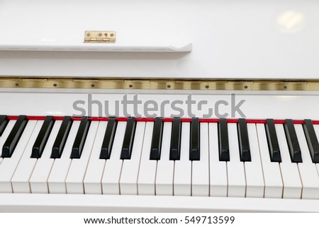 Close up  white piano, white and black keyboard