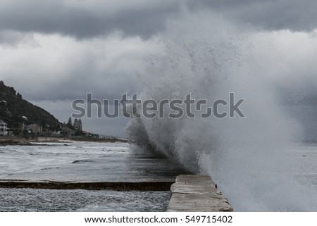 This is picture a big wave near breakwater in port. It is a excellent illustration in soft light.