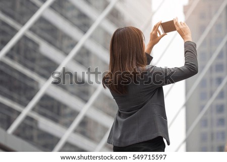 Business working woman in suit selfie, taking picture of  building in background