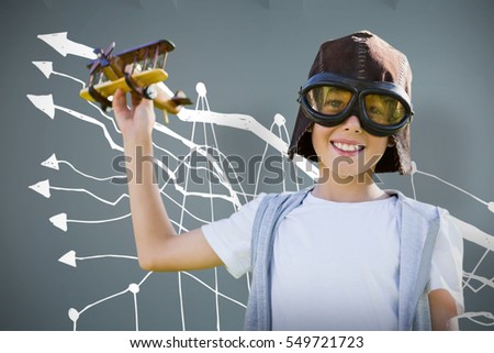 Portrait of boy wearing flying goggles with toy against room with wooden floor