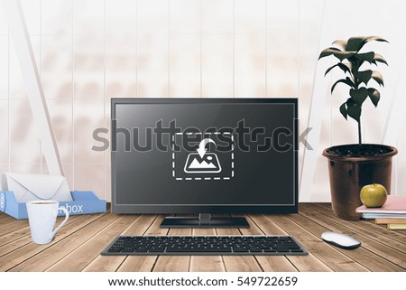 A computer over a desk against front of building with bright light
