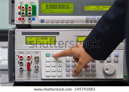 a man adjust a parameter of calibrator meter to make a calibration of electronic meter Royalty-Free Stock Photo #549741883