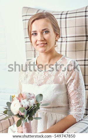 
European beautiful blonde bride in a white dress with a bouquet of flowers. Lace bride. Wedding studio portrait. Beautiful smiling of woman, girl, bride.