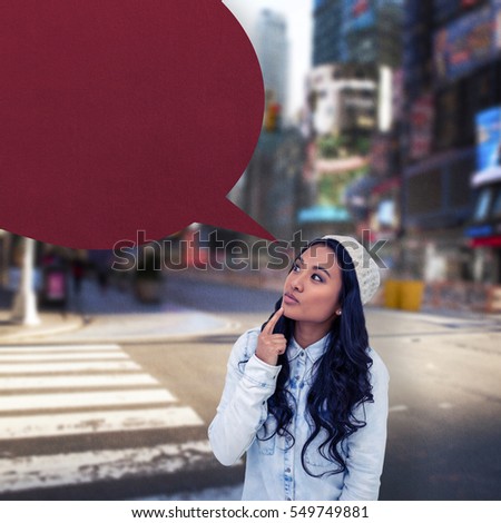 Asian woman with finger on chin against blurry new york street