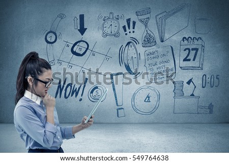 Asian businesswoman using tablet against grey room
