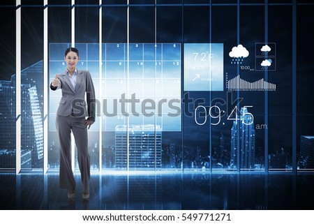 Portrait of a happy businesswoman posing with the thumb up against hologram interface in office overlooking city