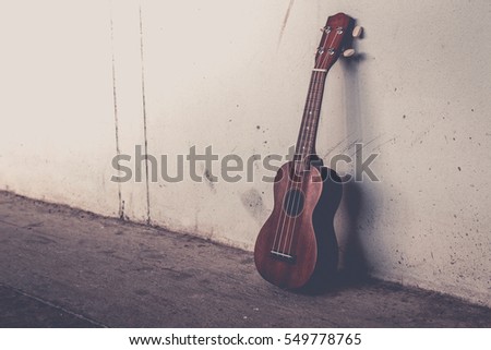 ukulele on gray wall background with shadow edge.vintage tone.
