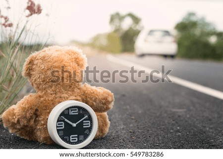 Vintage,White clock and Teddy Bear  on rural roads forest grass, the concept of using travel time, blank copy-space.