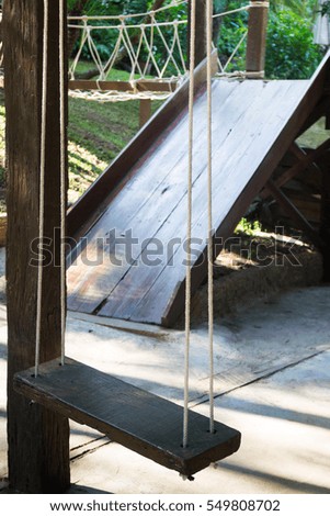 Empty wooden swing in the garden, stock photo