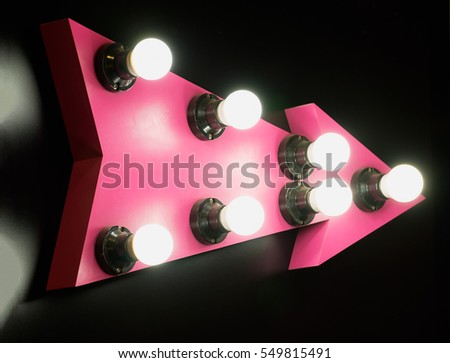 Signs with arrows pink bulbs on a black background.
