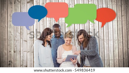 Happy woman holding digital tablet and discussing with coworkers against wooden planks background
