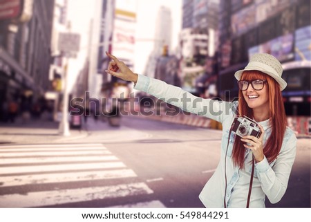 Attractive hipster photographing with camera against white background