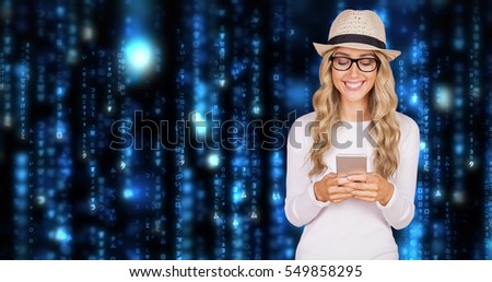 Gorgeous smiling blonde hipster using smartphone against lines of blue blurred letters falling