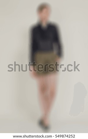 Womens fashion clothing theme creative abstract blur background with bokeh effect. Young woman demonstrates designer clothing piece in studio environment for internet store