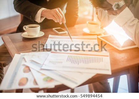Boss is clarifying about the margin target and year plan for his assistant on wooden working table. Selected focus at the end of pencil . Royalty-Free Stock Photo #549894454