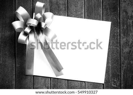 Blank white paper valentines or Christmas Greeting card with ribbon on dark old wooden table background. picture for add text message