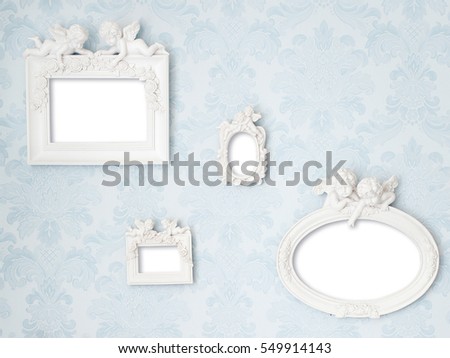 Beautiful vintage frames with Cupids on tender blue damask background. Wall with photo gallery