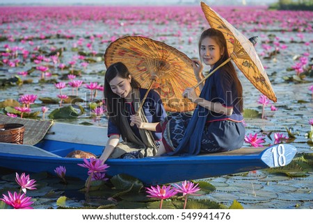 Pretty girl and the sea of red lotus , Thailand .