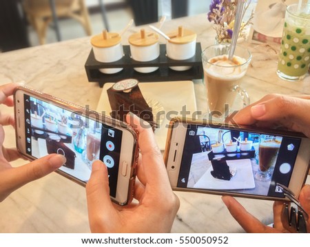 Close up people use smart phone to take picture of coffee cake before eat