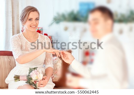 man makes a proposal to the girl. groom wears the ring on the bride's finger. happy bride blonde. Valentine's Day. wedding photography studio.