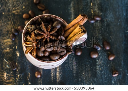 Vintage coffee mug with raw coffee beans on dark rustic wooden background