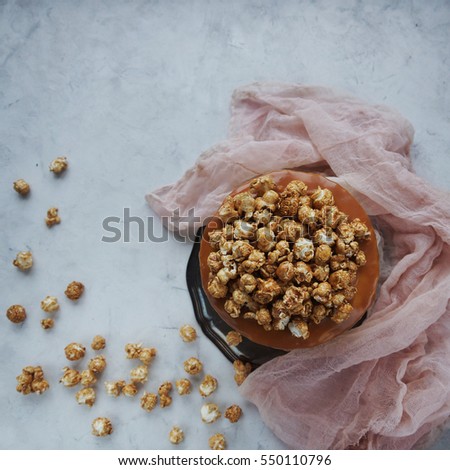 Vegan salted caramel cake decorated with popcorn in light rustic interior. Homemade caramelized cake for birthday, festive seasons, engagement or valentine day, selective focus, top view