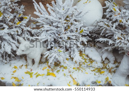 christmas decorations of family of polar white bears wich are sitting outside under the white christmas trees full of snow and yellow leaves