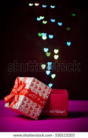 gift box open shaped heart with Defocused bokeh colorful lights heart shaped background