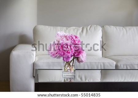 vase of pink peony flowers with white living room furniture
