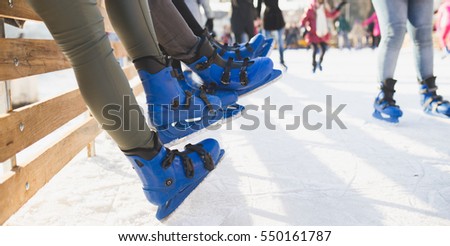 Close up shot of unrecognizable people legs in ice skates. 