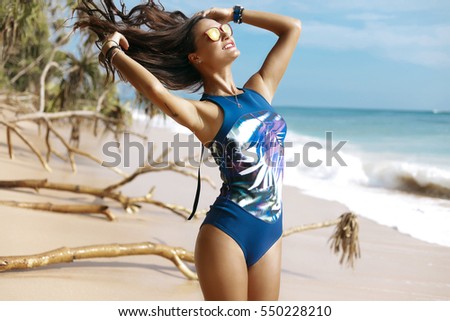 Enjoyment -free happy woman enjoying sunset,hair in the air.sunny,girl in  sportswear,bikini,swimwear.embracing golden sunshine glow of sunset with arms outspread and face raised in sky enjoying peace