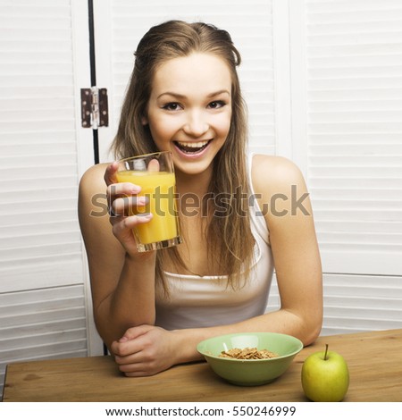 portrait of happy cute girl with breakfast, green apple and orange juice