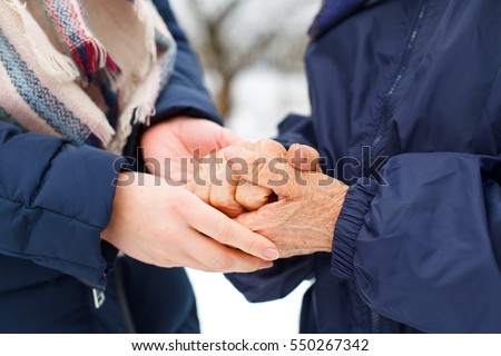 Close up picture of a woman holding her grandmother's aged hands