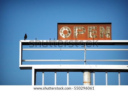  aged and worn vintage photo of open sign with bird                             
