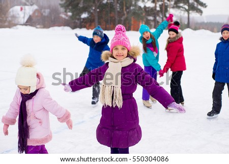 two young skater girls on the ice of the frozen lake. kids on the background