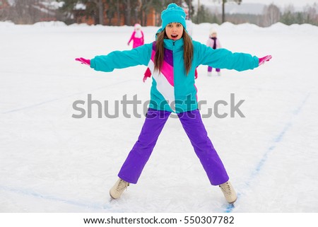 young attractive skater girl on the ice of the frozen lake. kids on the background
