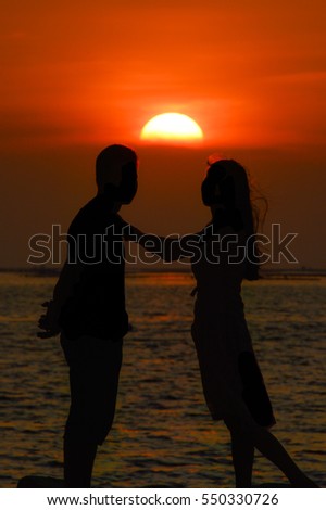 Romantic silhouette couple at sunset sea