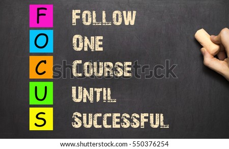 Conceptual FOCUS acronym written on black chalkboard blackboard