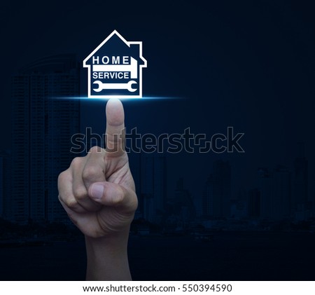 Hand pressing hammer and wrench with house icon over city tower background, Home service concept