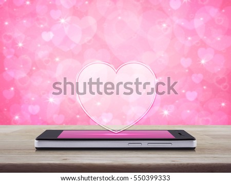 Love heart icon with copy space on modern smart phone screen on wooden table over blur pink background, Internet online love connection, Valentines day concept